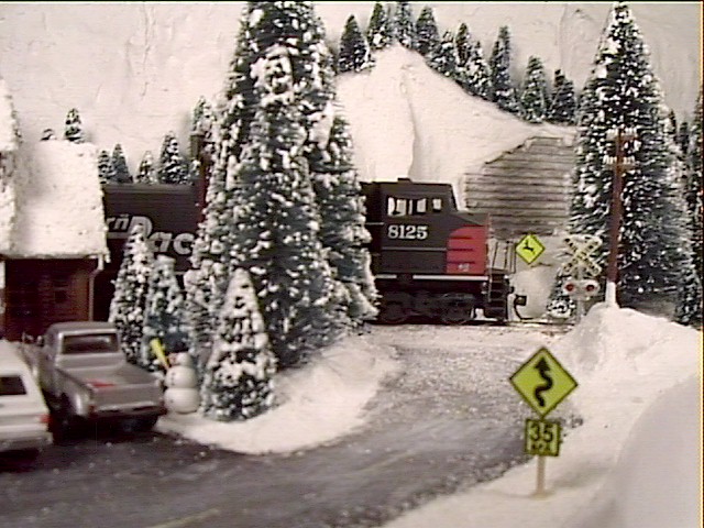 A Southern Pacific freight train crosses the road as it nears the summit
