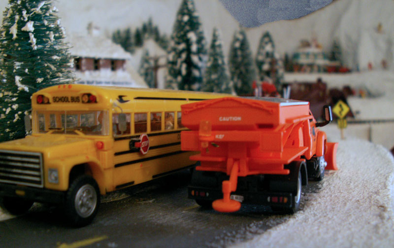 A snowplow clears the road through the forest on Wolf Mountain