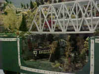 A close-up photo of the WNYSSA trestle module as an American Flyer model 362 Santa Fe locomotive crosses the trestle and a trolly appears on the lower track.