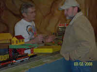 George Cole is discussing the merits of American Models trains with a guest.