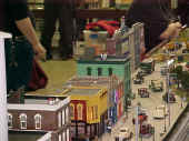 A street scene on the Flower City Tinplate Trackers club modular layout.  The CAFE sign is animated.